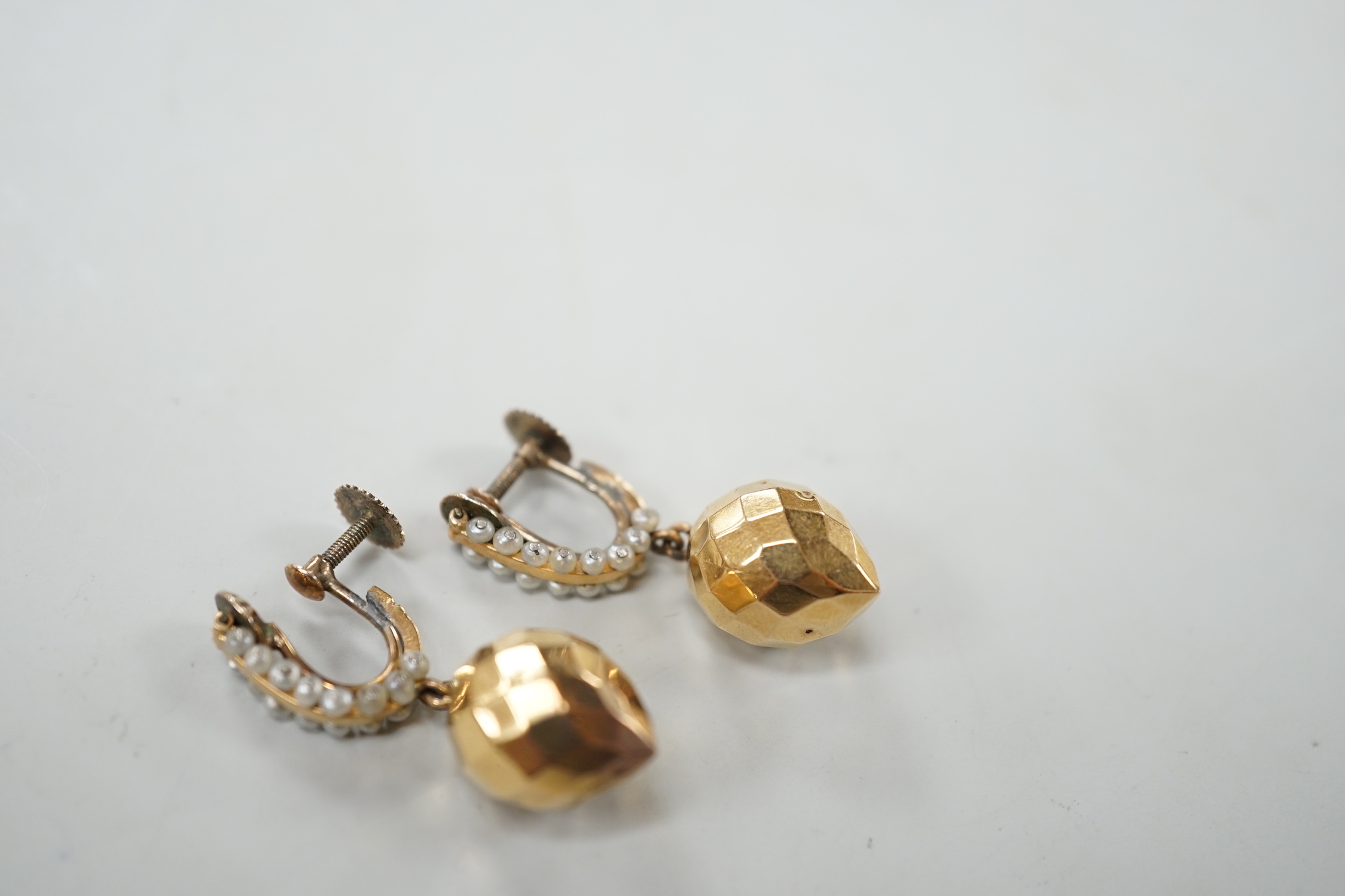 A pair of Victorian yellow metal and seed pearl 'facetted' drop ear clips, overall 34mm, gross weight 5.2 grams.